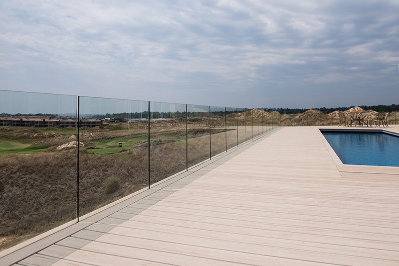 steel-studio-frameless-glass-balustrade-in-channel-on-deck-by-pool-overlooking-golf-course